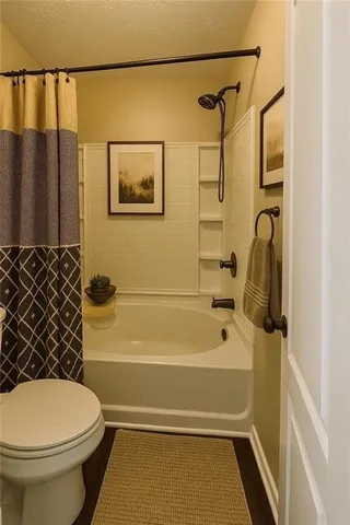 a bathroom with a toilet and a shower