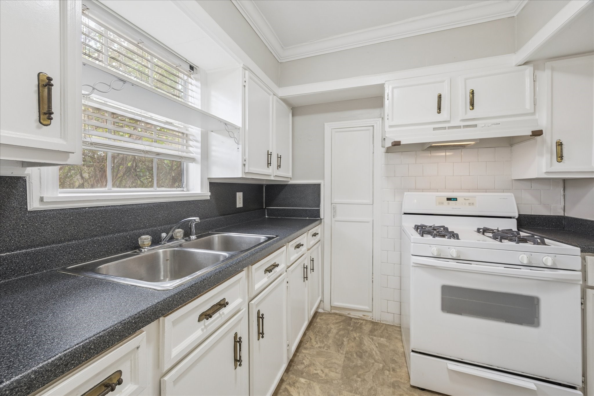 218 West 15th Street, Unit D Houston, TX 77008 - Photo 4 of 10 a kitchen with white cabinets sink and stove