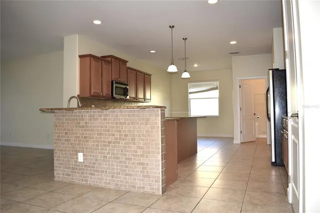 a kitchen with kitchen island a counter top space cabinets and stainless steel appliances