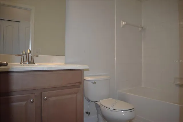 a bathroom with a sink toilet vanity and tub