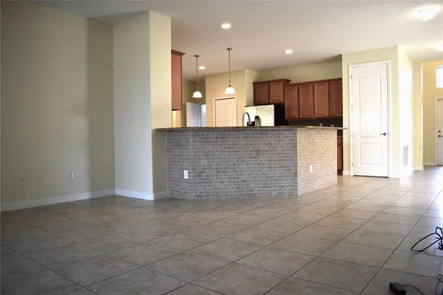a view of kitchen with kitchen island microwave and refrigerator