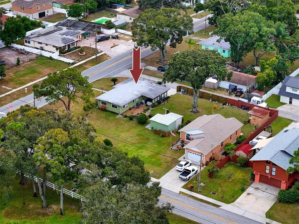 an aerial view of residential houses with outdoor space and trees