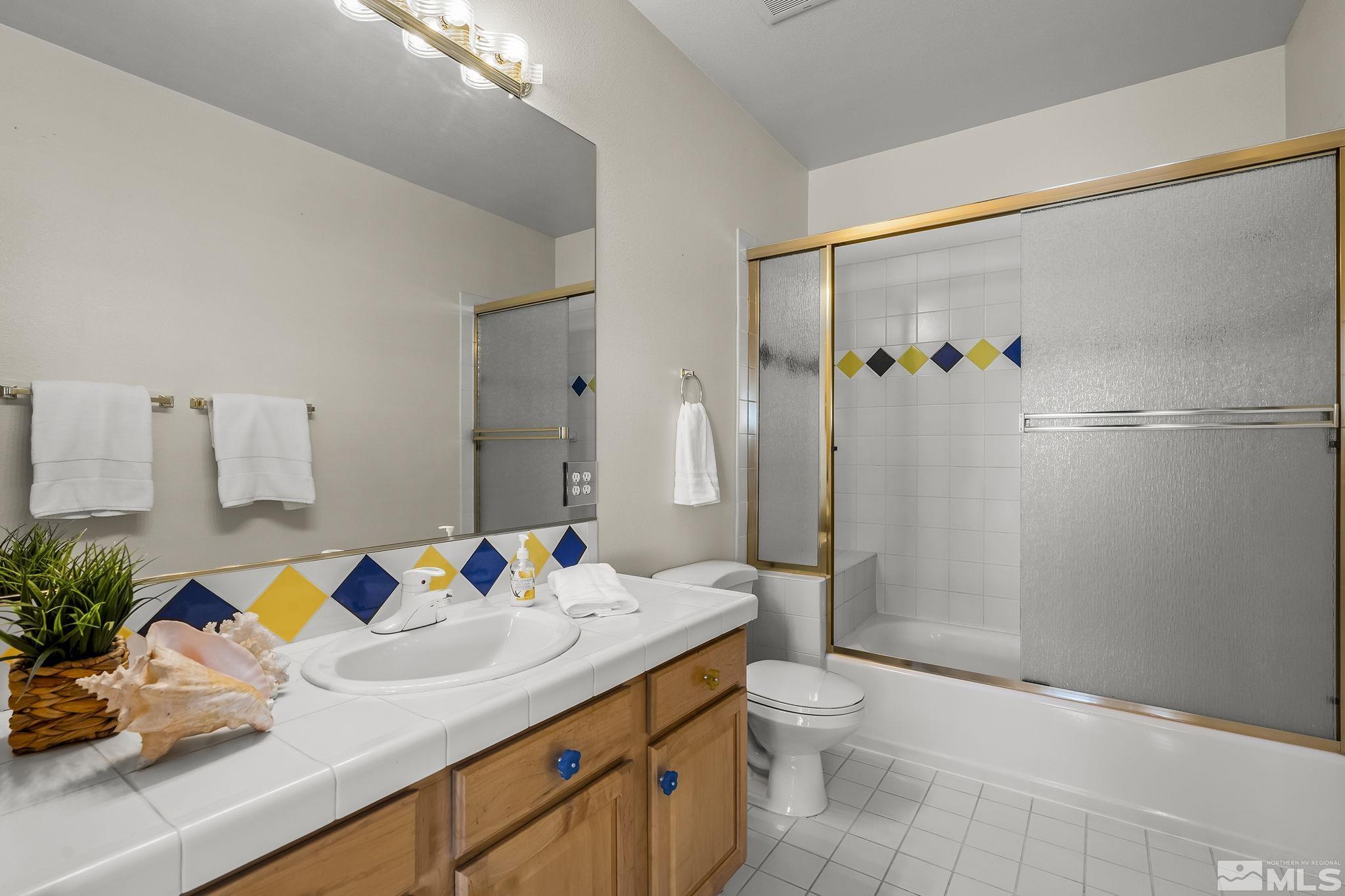 8755 Eaglenest Road Sparks, NV 89436 - Photo 34 of 40 a bathroom with a granite countertop sink a toilet and shower