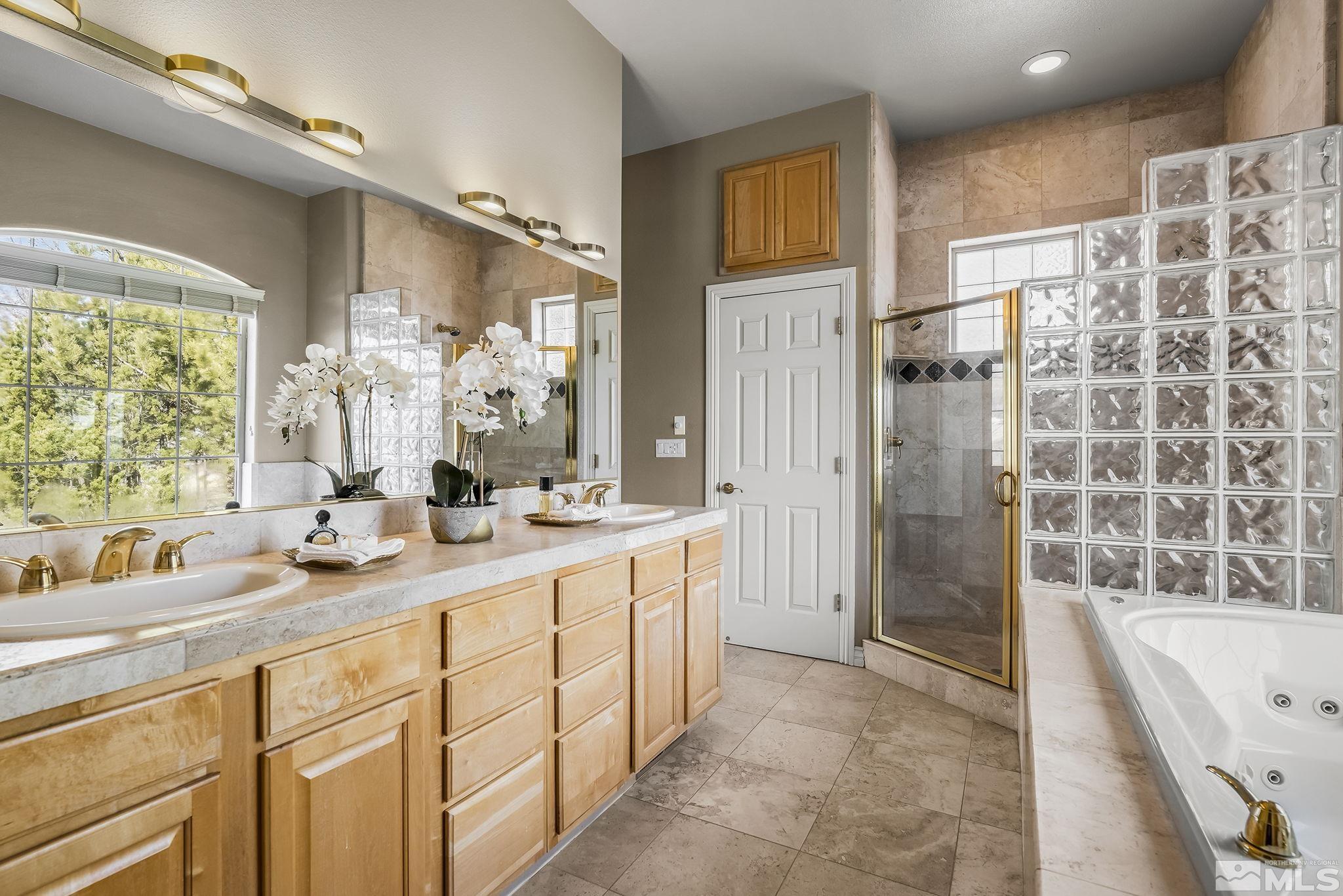 8755 Eaglenest Road Sparks, NV 89436 - Photo 9 of 40 a bathroom with a double vanity sink toilet mirror and bathtub
