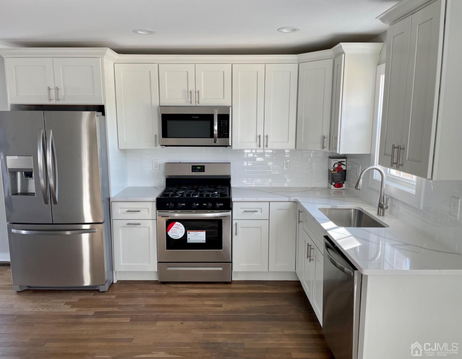 405 Crows Mill Road Fords, NJ 08863 - Photo 4 of 20 a kitchen with stainless steel appliances granite countertop a refrigerator stove and white cabinets