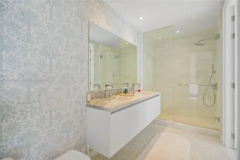 a bathroom with a granite countertop sink a toilet and shower