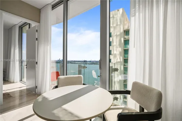 a living room with furniture and a floor to ceiling window
