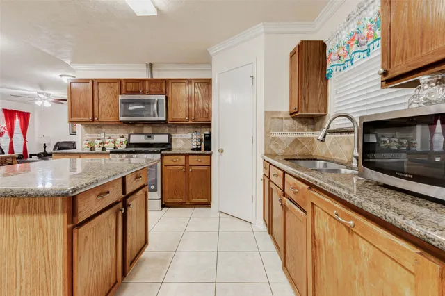 a kitchen with stainless steel appliances granite countertop a refrigerator sink and stove