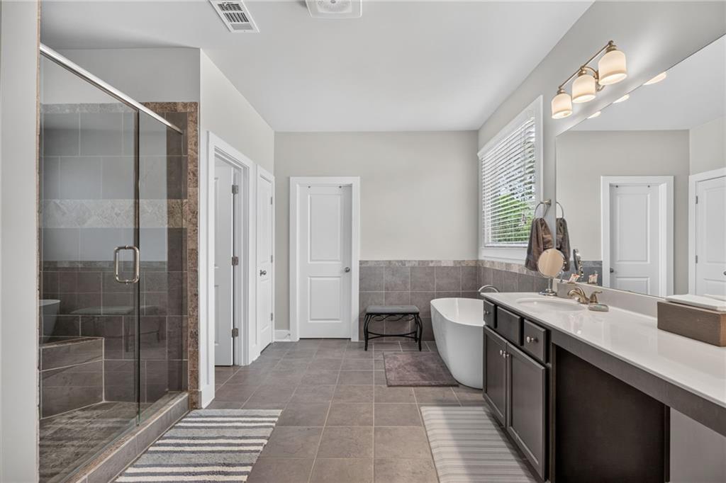 139 Manchester Lane Villa Rica, GA 30180 - Photo 33 of 60 a bathroom with a double vanity sink a toilet and shower