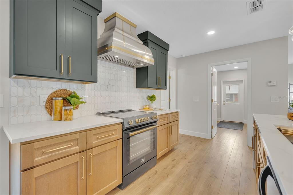350 Cornwall Road Winter Park, FL 32792 - Photo 15 of 36 a kitchen with stainless steel appliances granite countertop a sink a stove and wooden floors