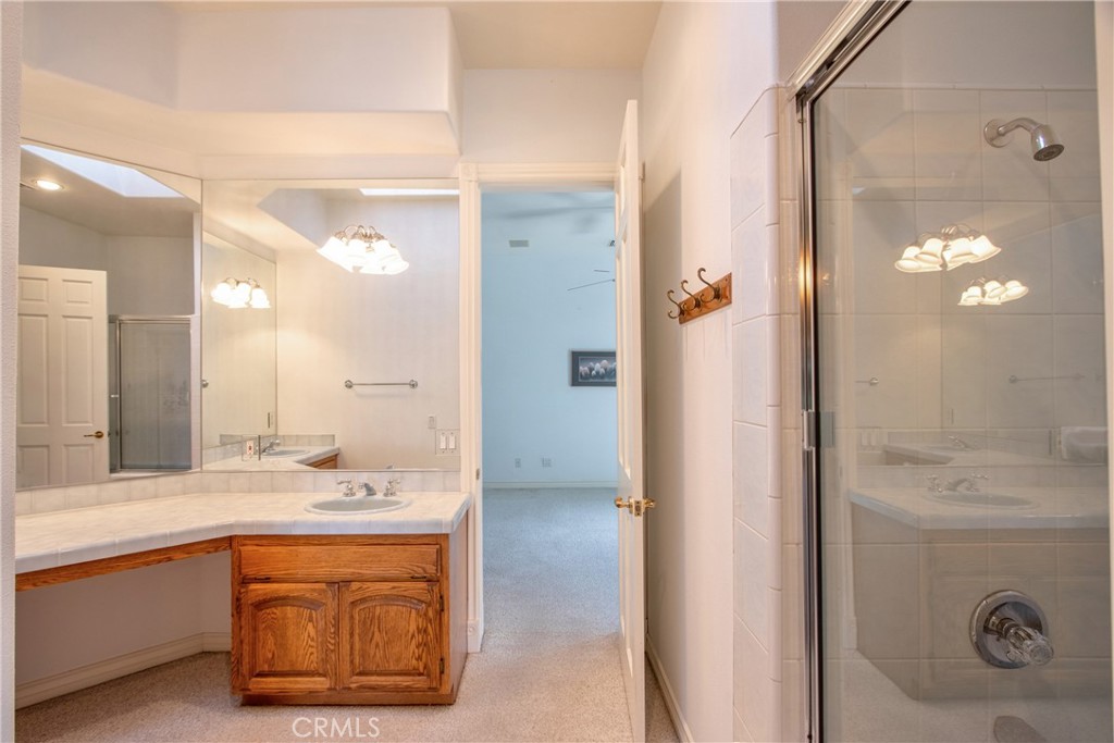 46856 El Prado Road Temecula, CA 92590 - Photo 42 of 75 a bathroom with a granite countertop sink mirror and shower