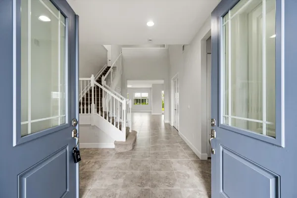 a view of staircase with lots of frames on wall and a window