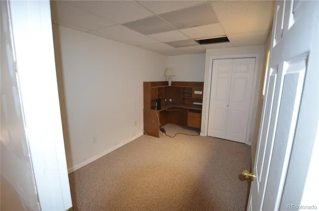 a view of empty room with refrigerator