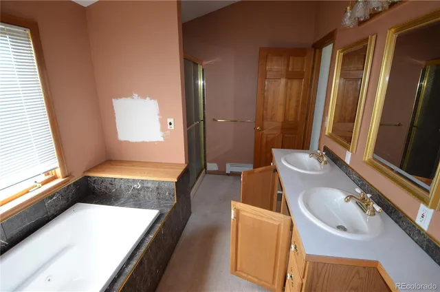 a bathroom with a tub sink and mirror