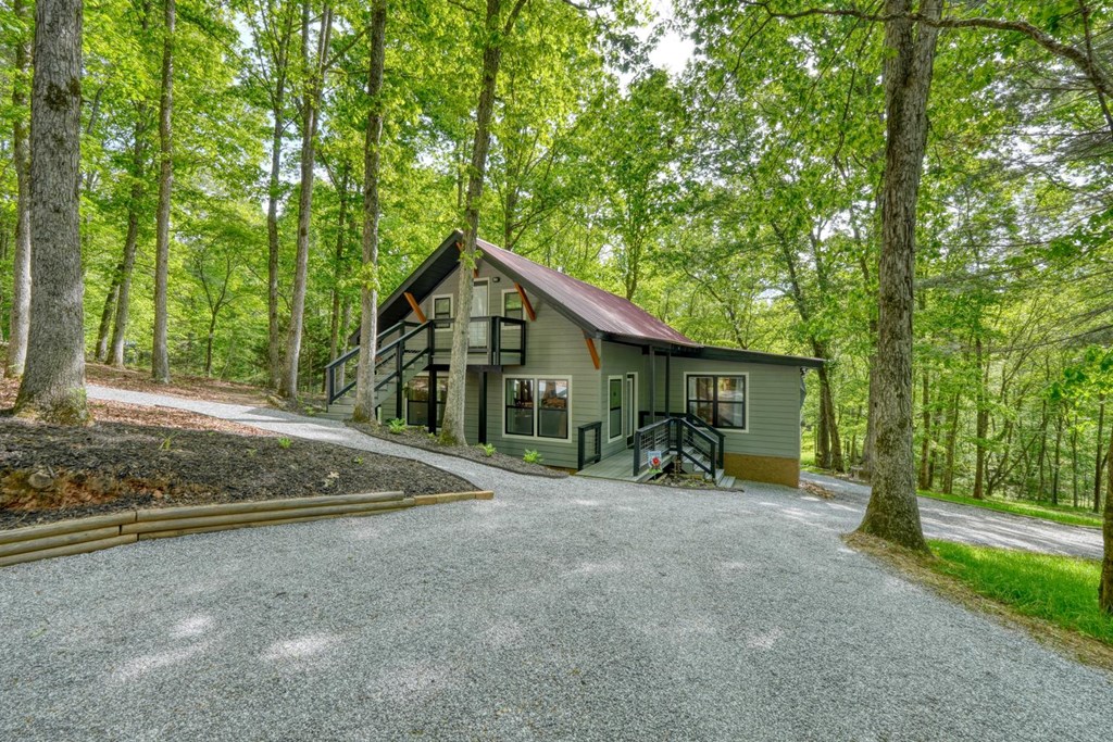 919 New Hope Road Morganton, GA 30560 - Photo 7 of 52 a view of a wooden house with large trees and wooden fence