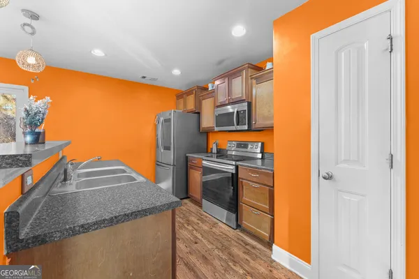 a kitchen with a sink a stove and a wooden floor