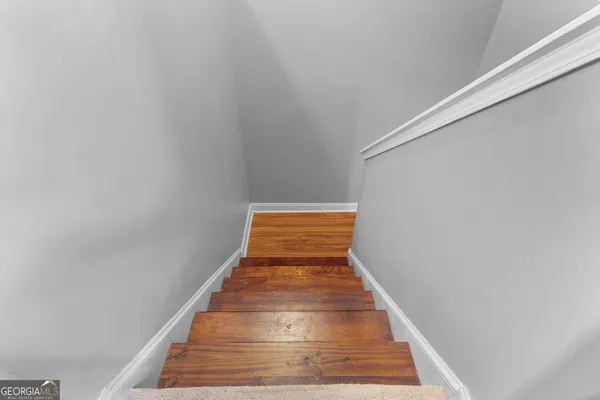 a view of a hallway with wooden floor and staircase