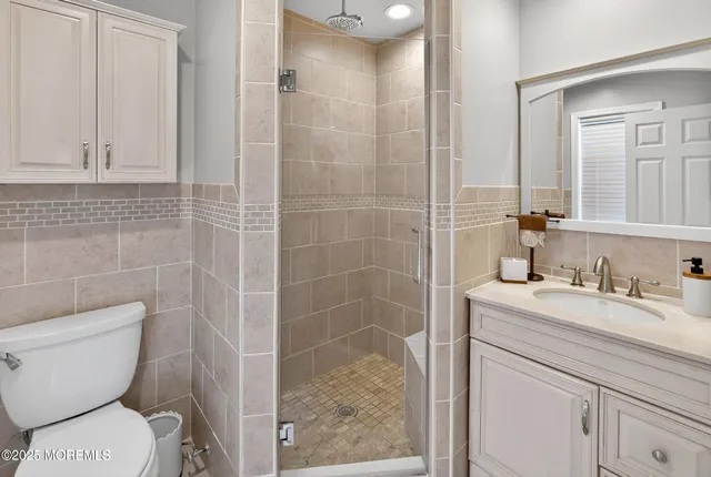 a bathroom with a granite countertop toilet sink and mirror