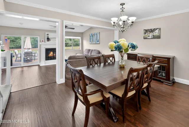 a dining room with furniture a chandelier and wooden floor