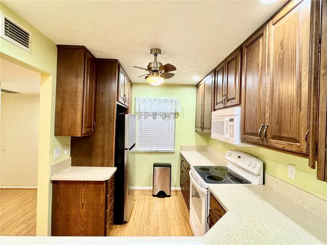 a kitchen with stainless steel appliances granite countertop a sink a stove and a refrigerator