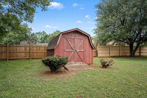 a backyard of a house with table and chairs