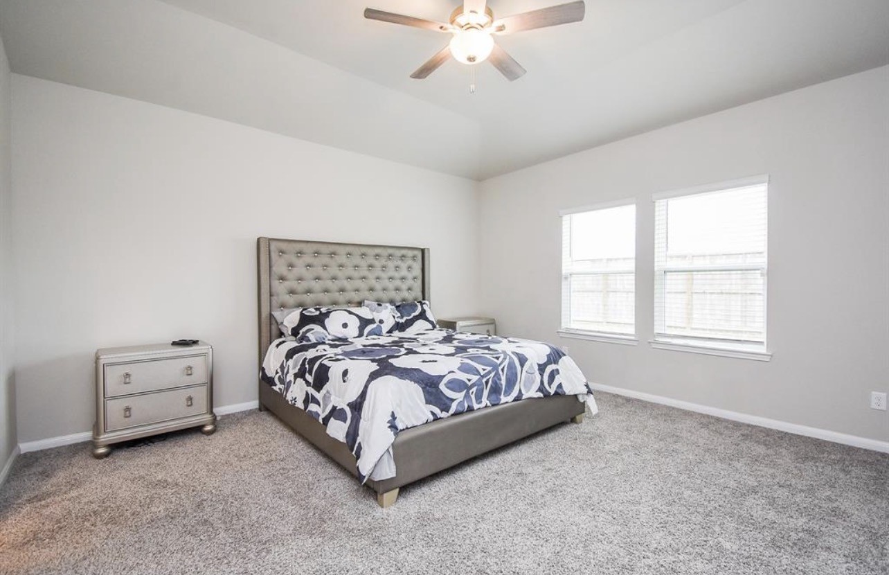6927 Ventura Drive Rosharon, TX 77583 - Photo 13 of 24 a bed sitting in a bedroom next to a window and a chandelier