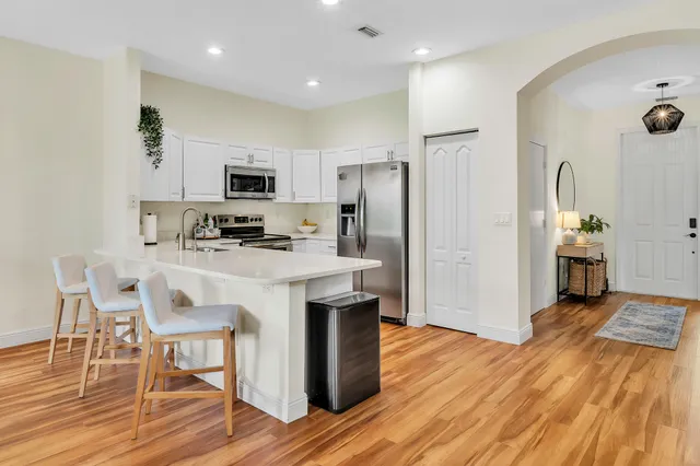 a kitchen with stainless steel appliances kitchen island a refrigerator sink and cabinets