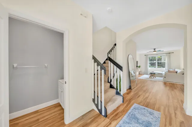 a view of staircase with wooden floor and white walls