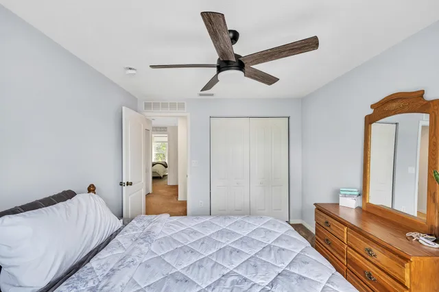a large bedroom with a bed and a flat tv screen on dresser