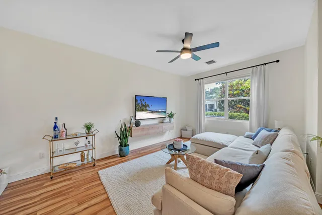a living room with furniture a flat screen tv and a large window