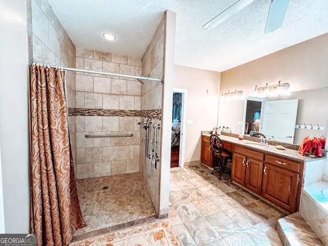 a large bathroom with a glass shower door and a sink