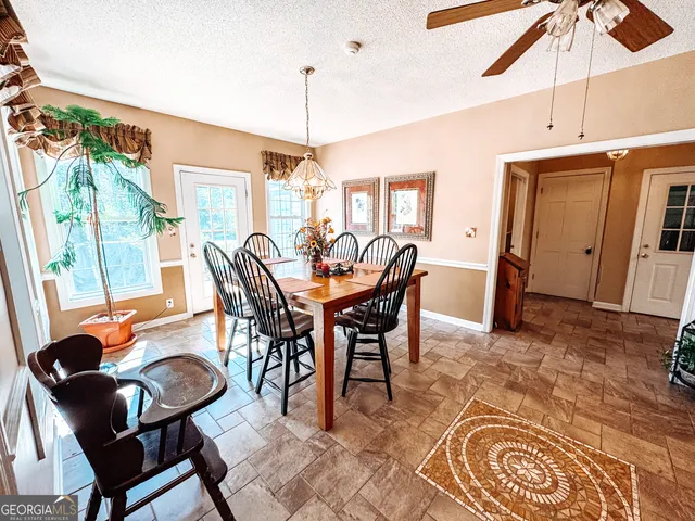 a dining room with furniture a chandelier and wooden floor