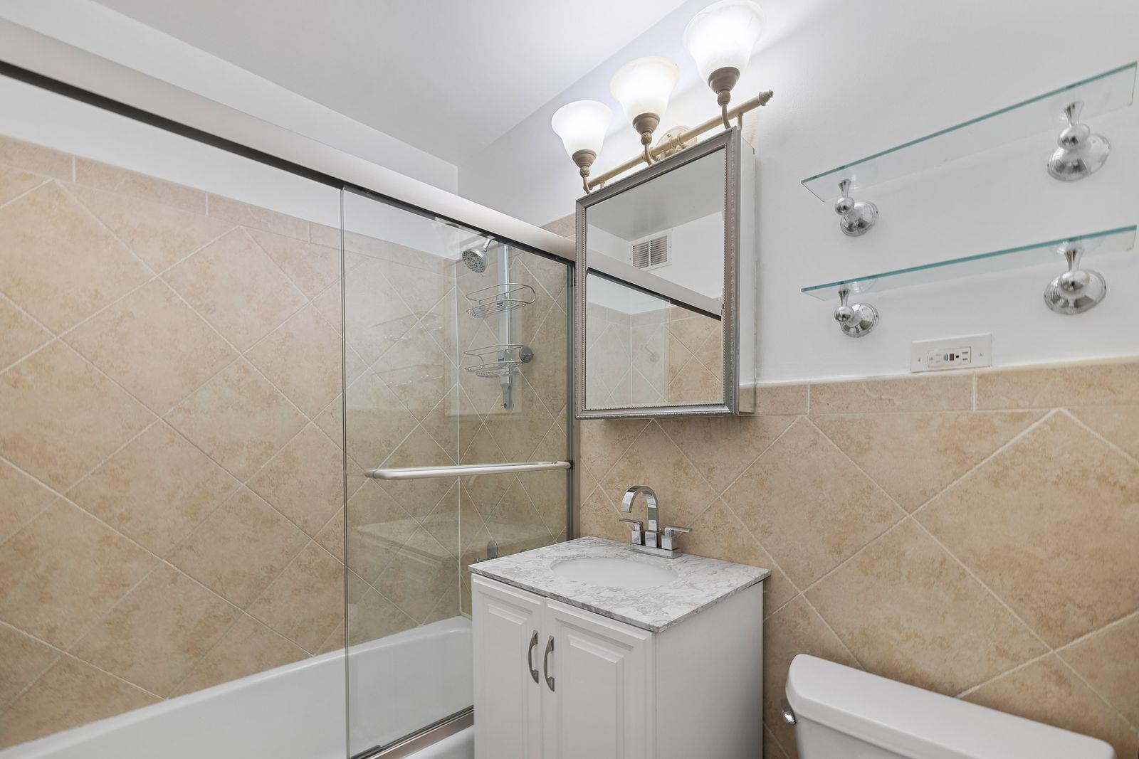 160 West End Avenue, Unit 8C Manhattan, NY 10023 - Photo 2 of 5 a bathroom with a sink a toilet and shower