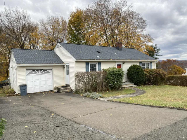 a view of a house with a yard and large tree