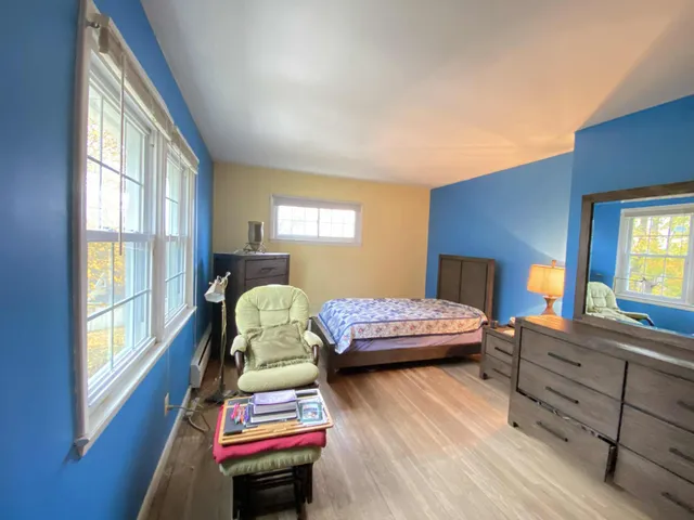 a bedroom with a bed window and dresser