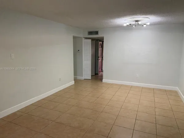 a view of an empty room with a chandelier fan