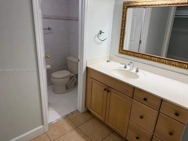 a spacious bathroom with a toilet sink and mirror