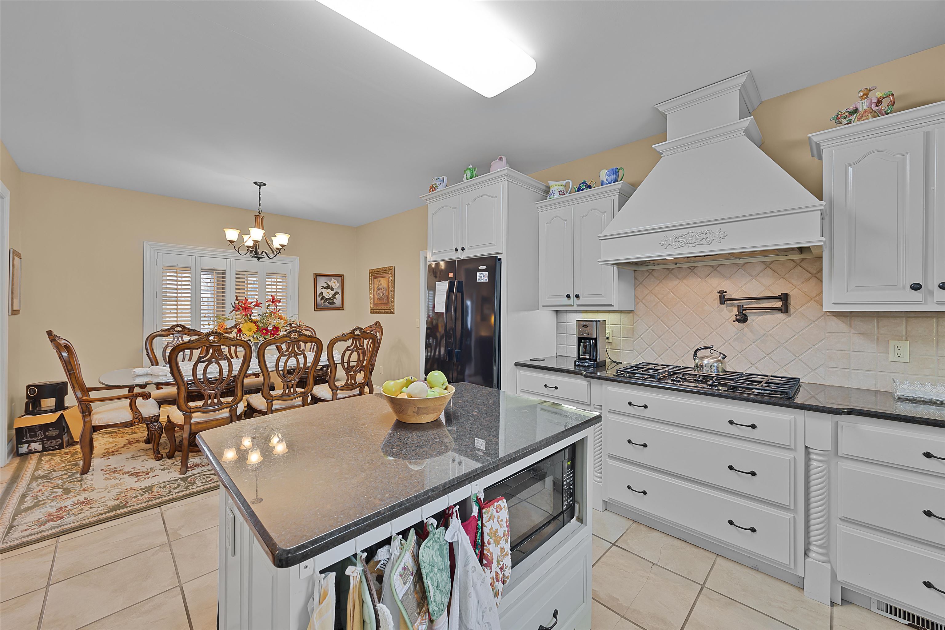 180 Strobbe Lane Counce, TN 38326 - Photo 7 of 25 a kitchen with granite countertop a table chairs stove and cabinets