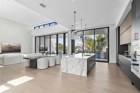 a large white kitchen with a large window and stainless steel appliances