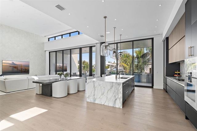 a large white kitchen with a large window and stainless steel appliances