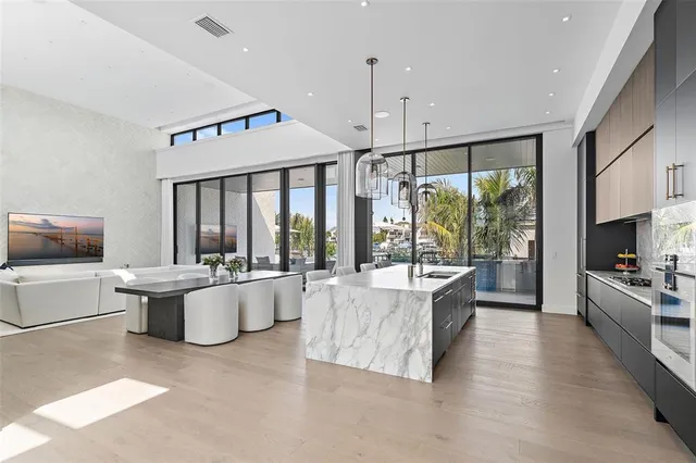 a large white kitchen with a large window and stainless steel appliances