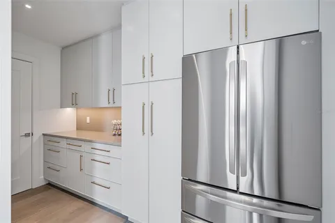 a kitchen with white cabinets and white appliances