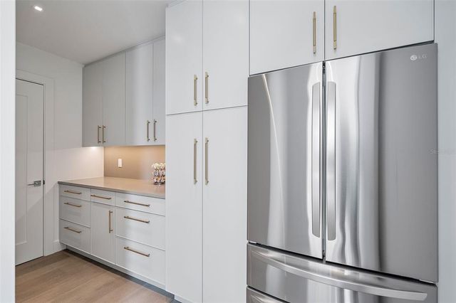 a kitchen with white cabinets and white appliances