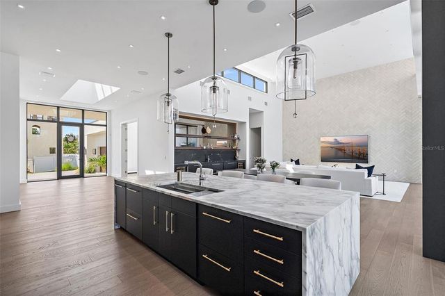 a kitchen with a sink a center island and wooden floor