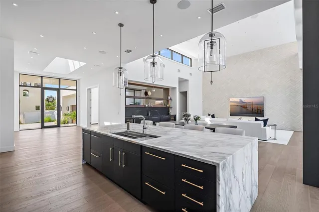 a kitchen with a sink a center island and wooden floor
