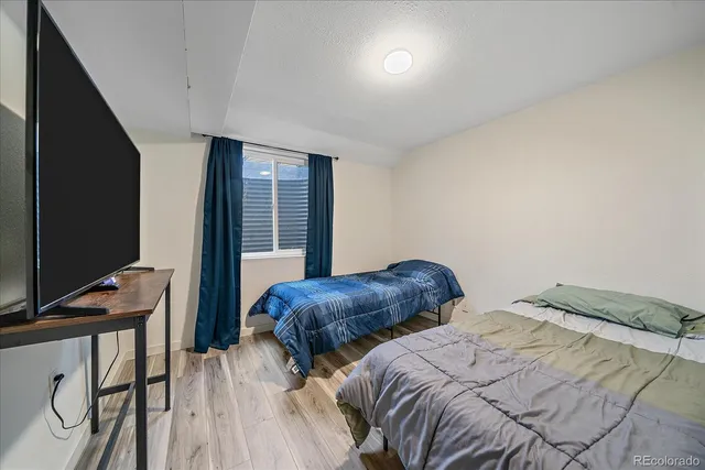 a bedroom with two bed and a desk