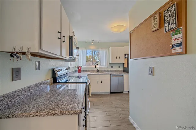 a kitchen with a sink refrigerator and cabinets