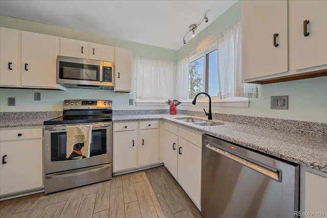 a kitchen with granite countertop a sink stove and microwave
