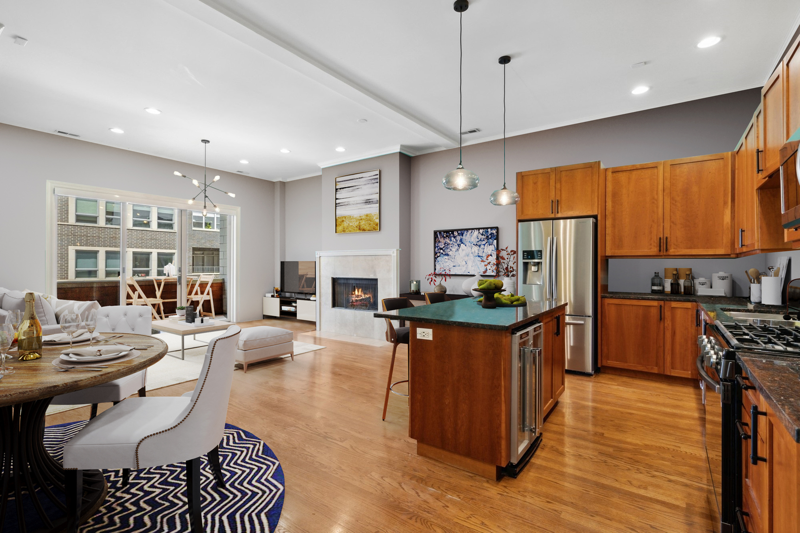1555 North Wood Street, Unit 302 Chicago, IL 60622 - Photo 3 of 14 a kitchen with stainless steel appliances kitchen island granite countertop a refrigerator a stove a sink a dining table and chairs with wooden floor
