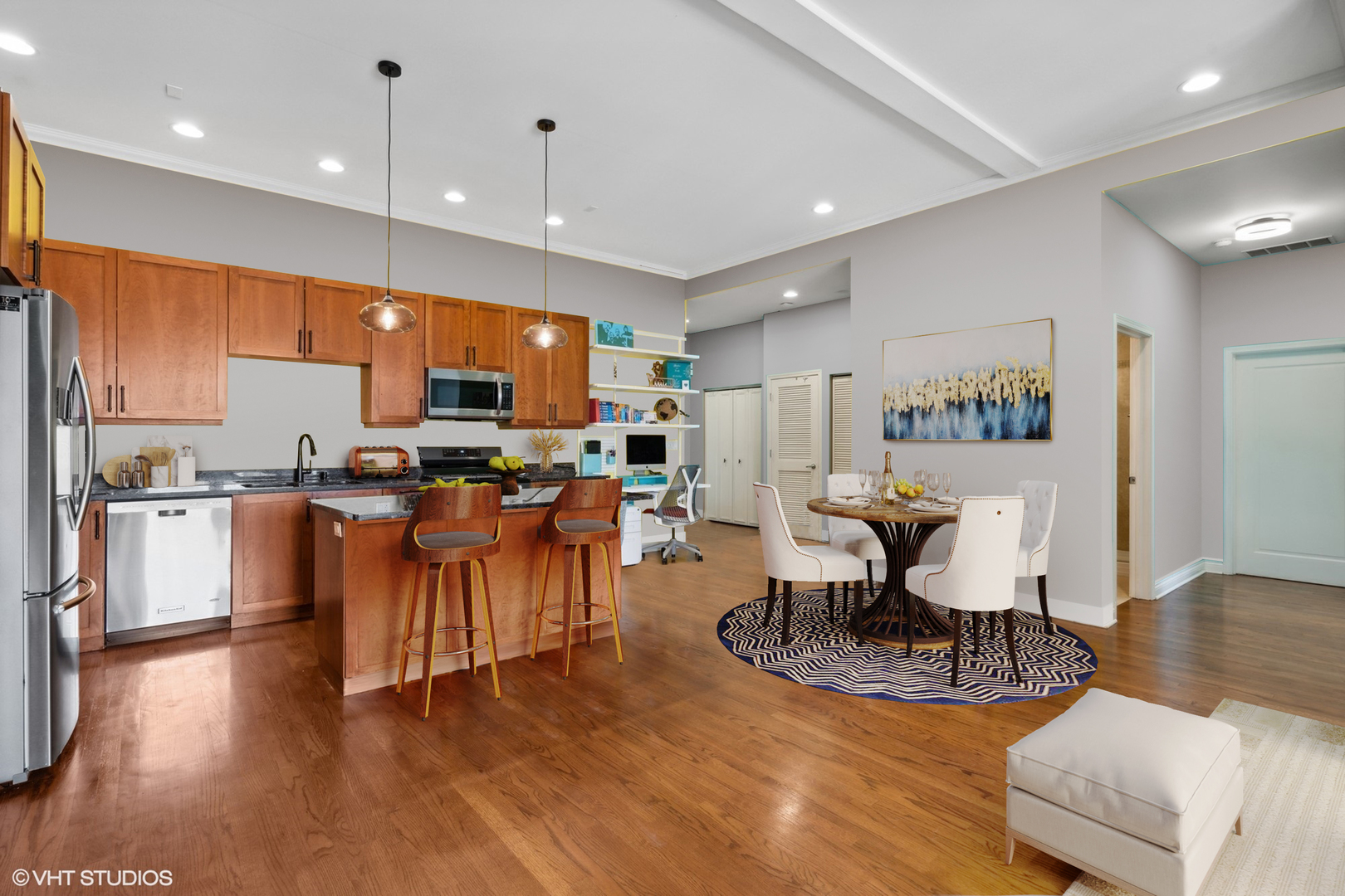 1555 North Wood Street, Unit 302 Chicago, IL 60622 - Photo 7 of 14 a kitchen with stainless steel appliances lots of white furniture wooden floor and a refrigerator